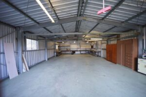 Empty garage with a bare gray concrete floor waiting to be prepped and coated