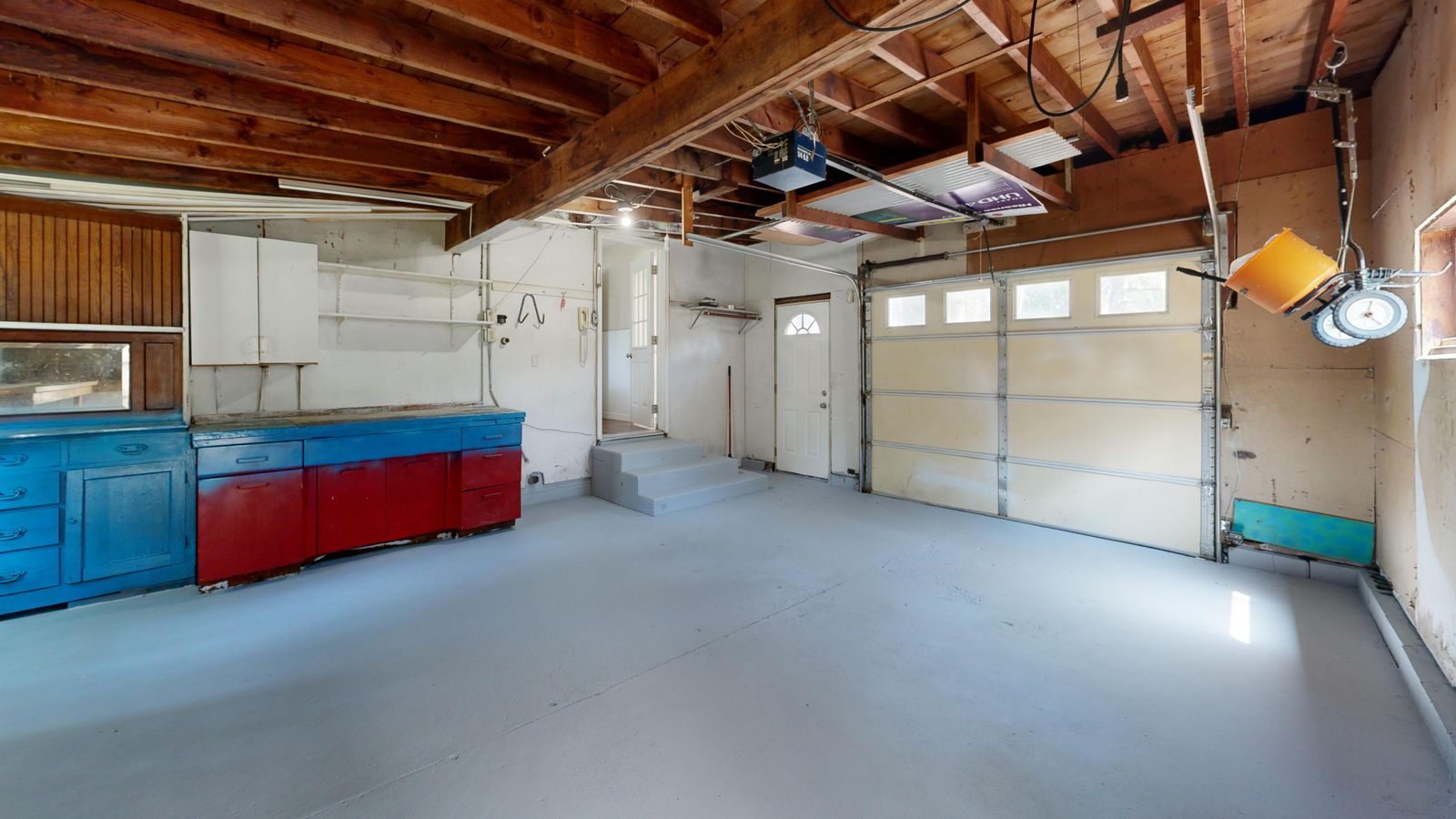 Finished garage with a smooth coated floor, cabinets, and clear working space