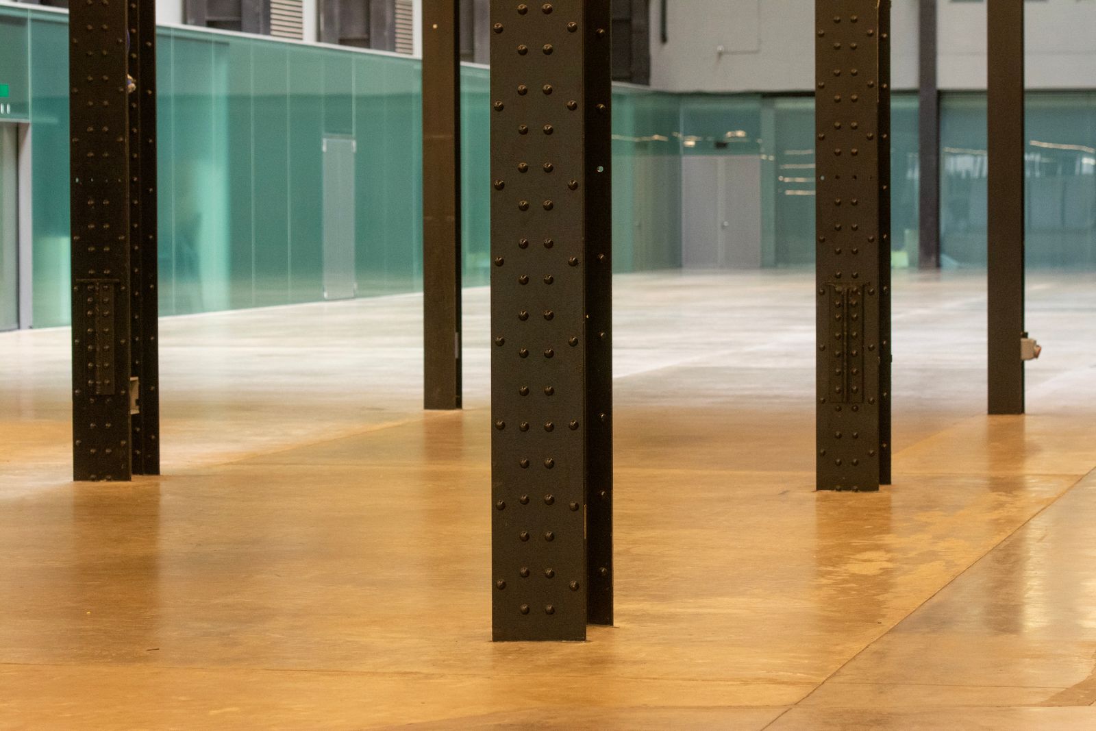 polished concrete floor with a soft sheen running between steel columns in an open industrial space