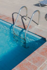 Bright pool deck with a metal ladder and a finished walking surface