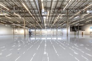 Glossy coated warehouse floor running between industrial racking