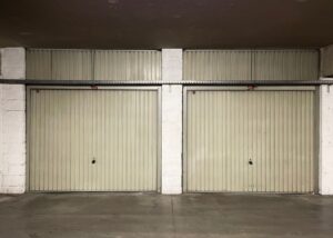 Two-car garage with a bare, worn concrete floor before coating