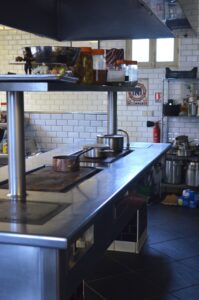 Empty commercial kitchen with stainless steel equipment and a hard floor surface