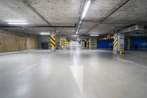 Light gray coated concrete floor in a parking garage with painted arrows
