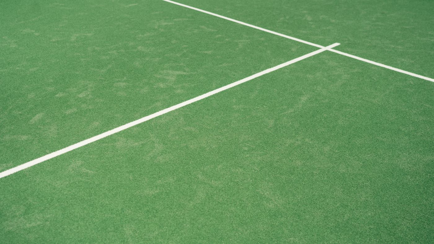 Green tennis court surface with fresh white line markings