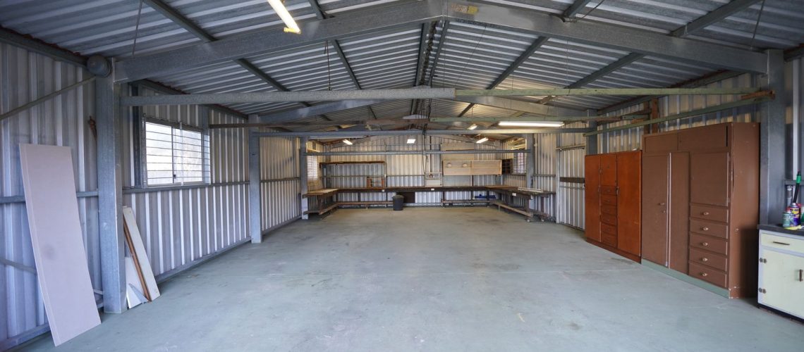 Empty garage with a bare gray concrete floor waiting to be prepped and coated