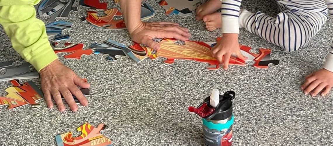 Two children playing on a grey flake rec room floor coating