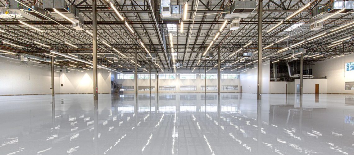 High gloss gray epoxy floor coating across a large open commercial space