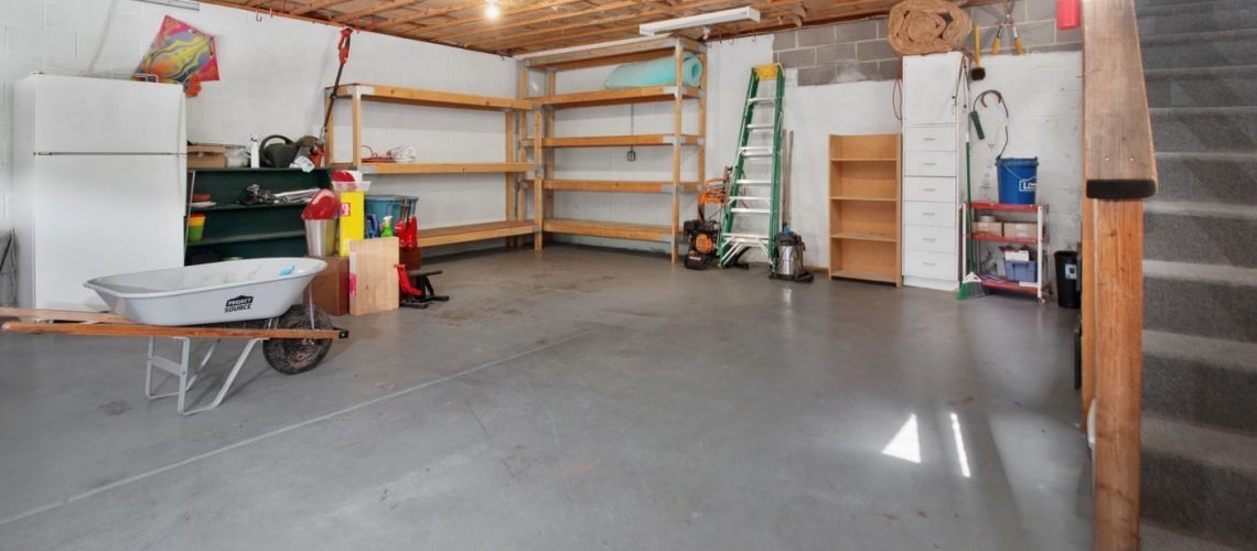Residential garage interior with storage shelving and a bare concrete floor