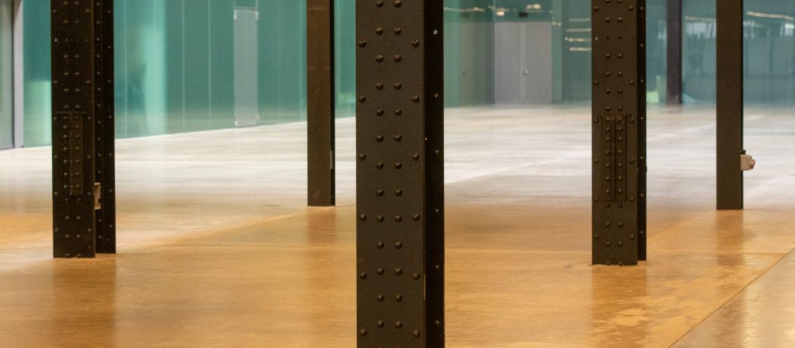 Polished concrete floor reflecting light between structural columns