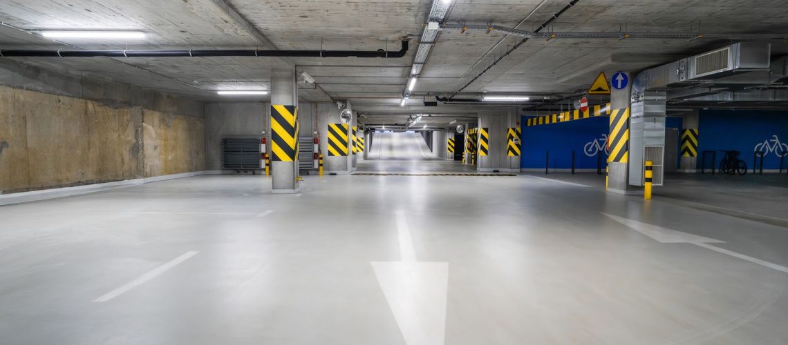 Light gray coated concrete floor in a parking garage with painted arrows