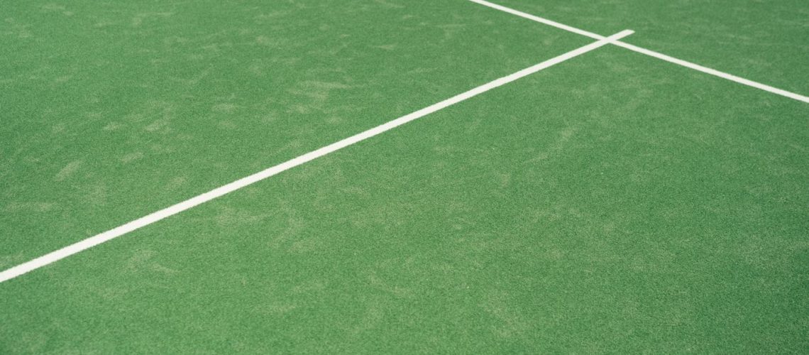 Green tennis court surface with fresh white line markings