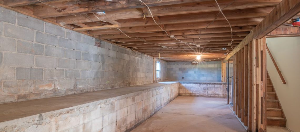 Unfinished basement with a bare concrete slab ready for a floor coating